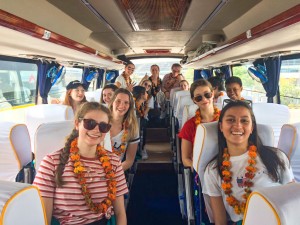 Students on coach in India marigold leis
