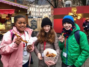 Happy students eating churros at Lille christmas market